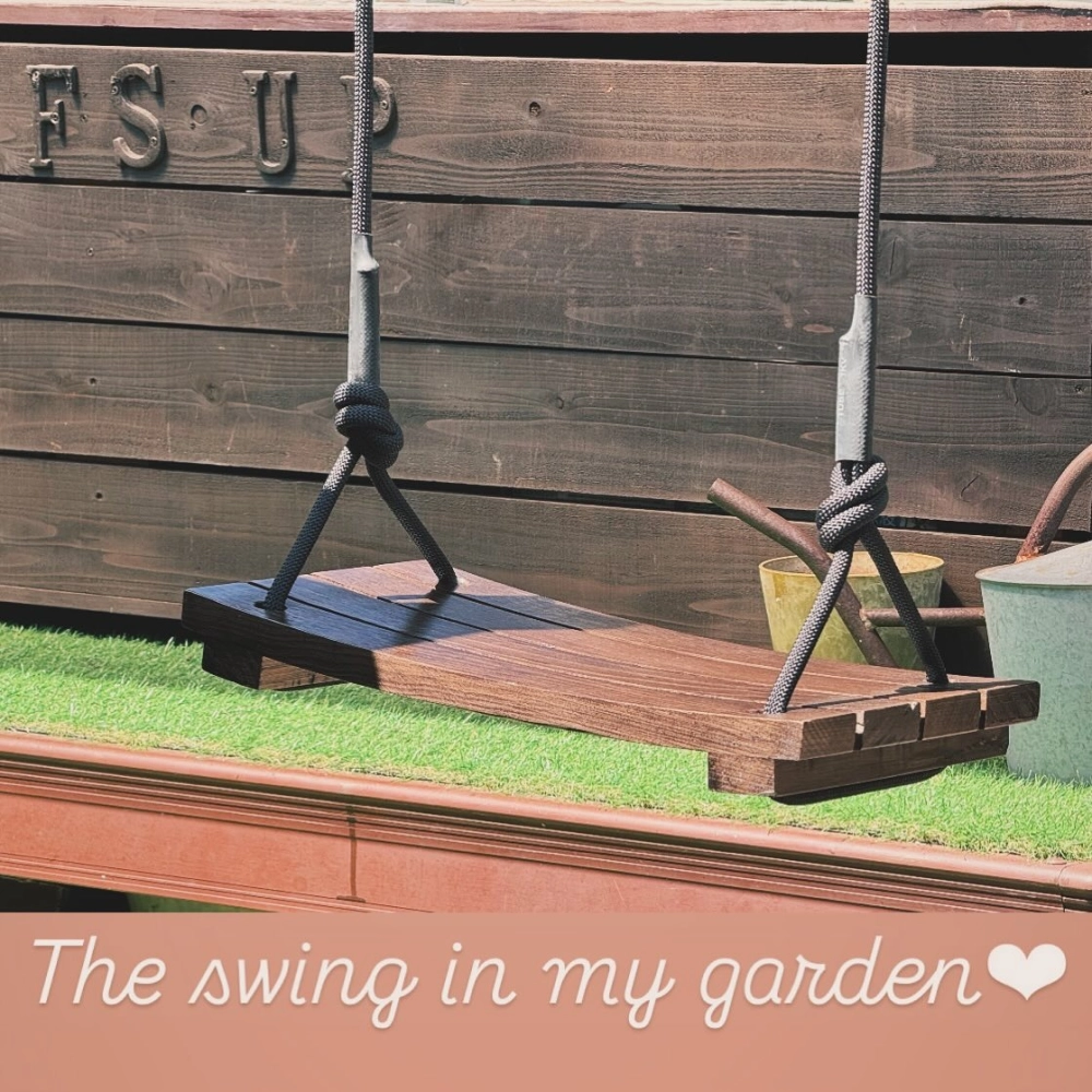 Mẫu xích đu sân vườn đẹp bằng gỗ tự nhiên đặt giữa thảm cỏ xanh