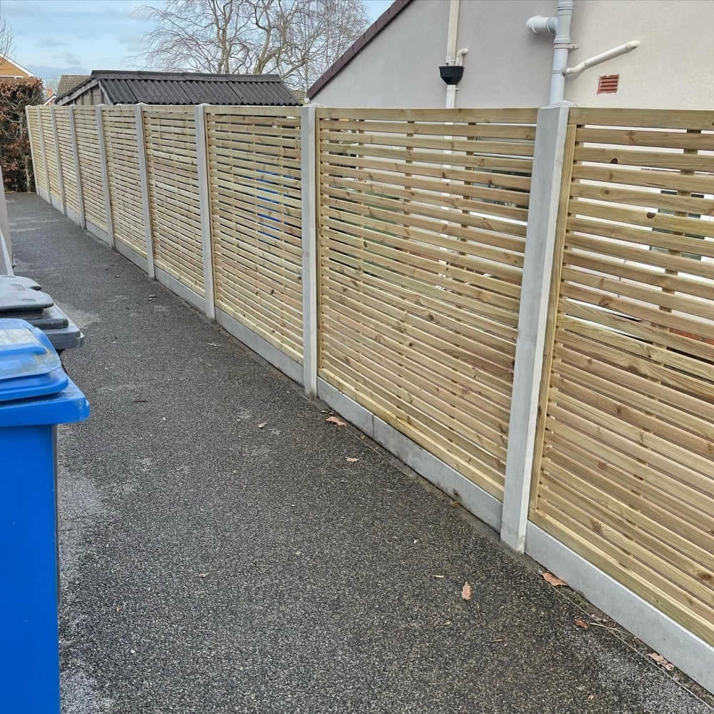 Thiết kế hàng rào sân vườn bằng các tấm gỗ nan ngang kết hợp trụ bê tông kiên cố chạy dọc lối đi