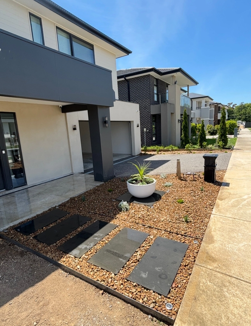 Những viên sỏi trang trí sân vườn màu trắng tạo nên lối đi hiện đại